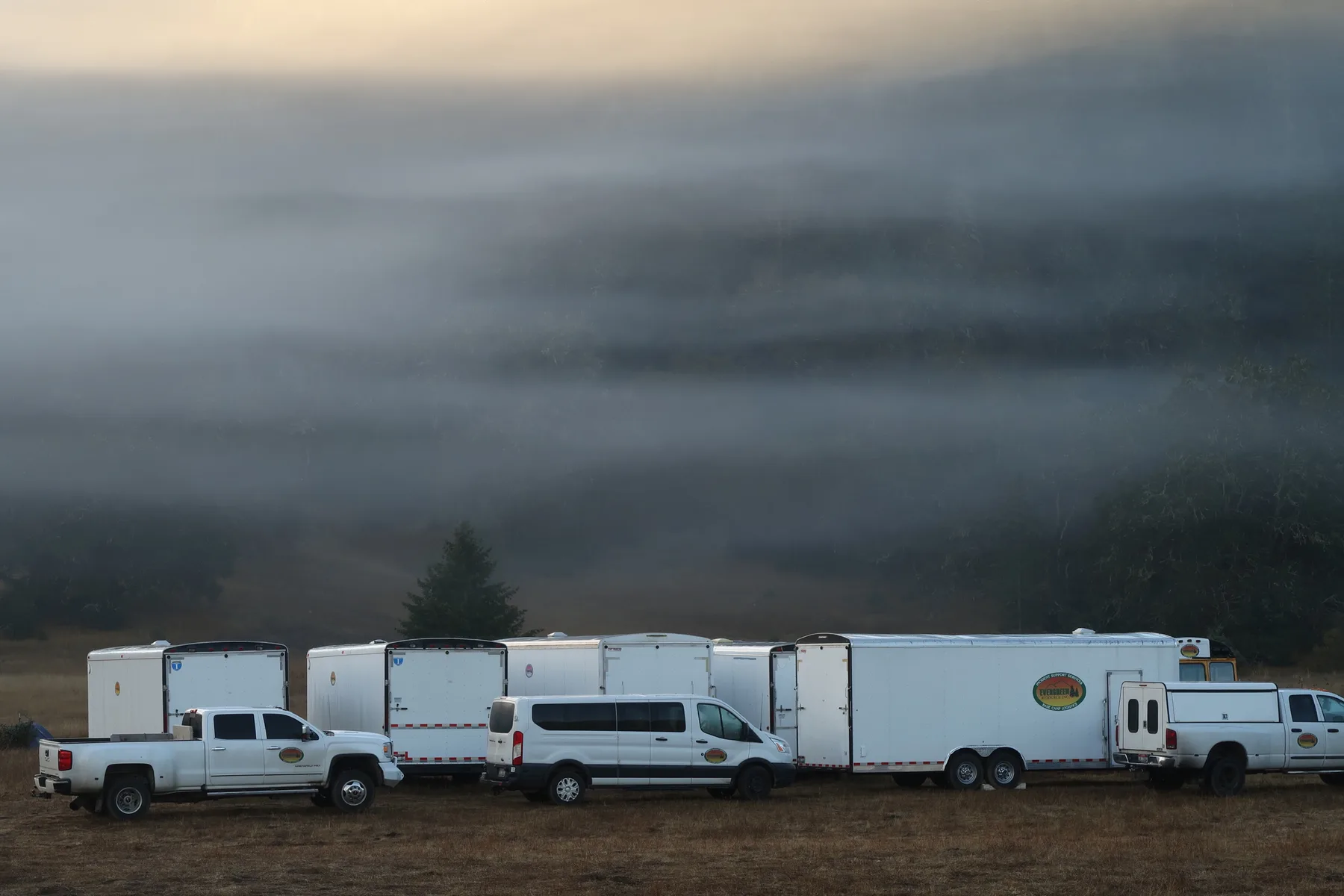 The Evergreen Resource fleet of trucks and trailers staged at dawn in fog