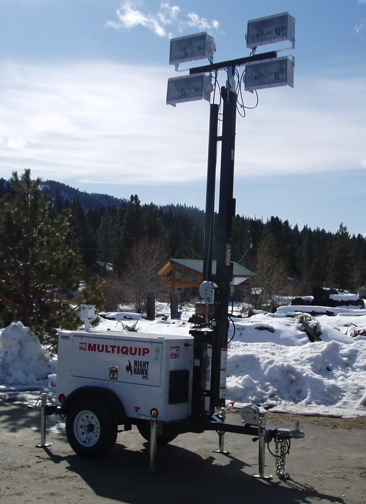 A telescoping Evergreen light tower with quad floodlights staged on a trailer