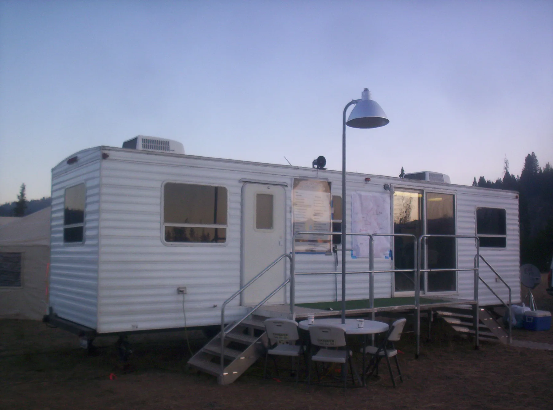 The Evergreen clerical support trailer staged at dusk at a base camp
