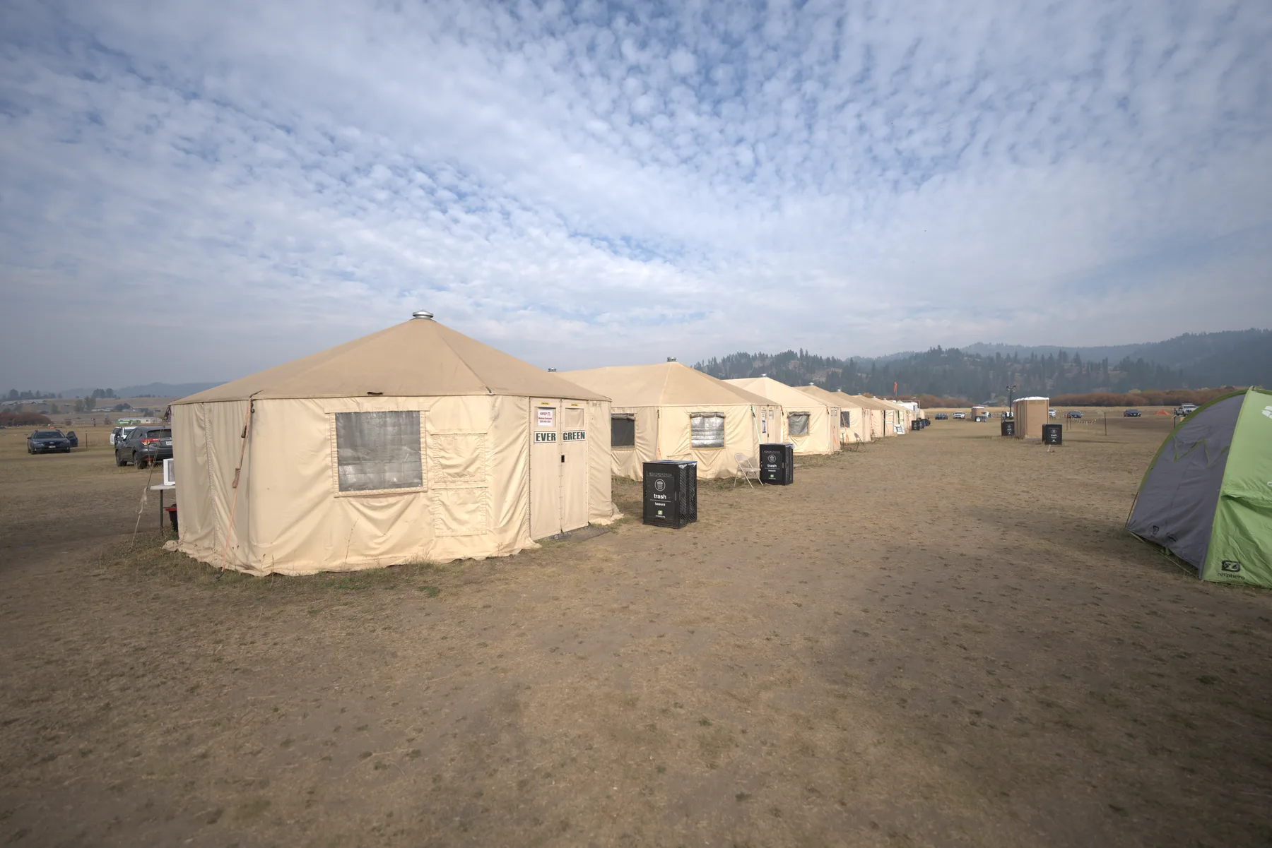 A row of Evergreen Resource yurts at smoky dawn with the camp coming to life