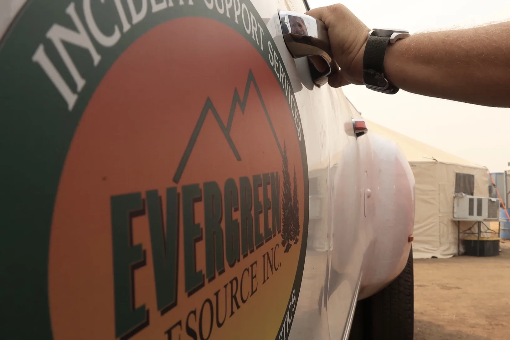 A close-up of the Evergreen Resource Incident Support Services sticker being placed on equipment