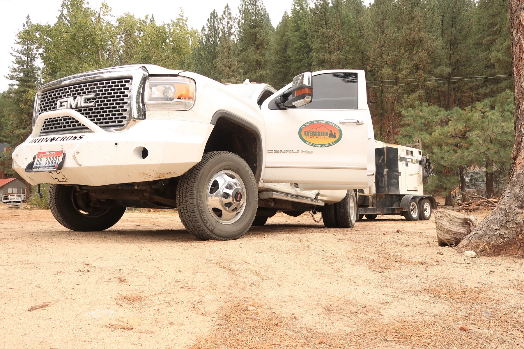 An Evergreen Resource truck, trailer, and generator staged at the edge of camp