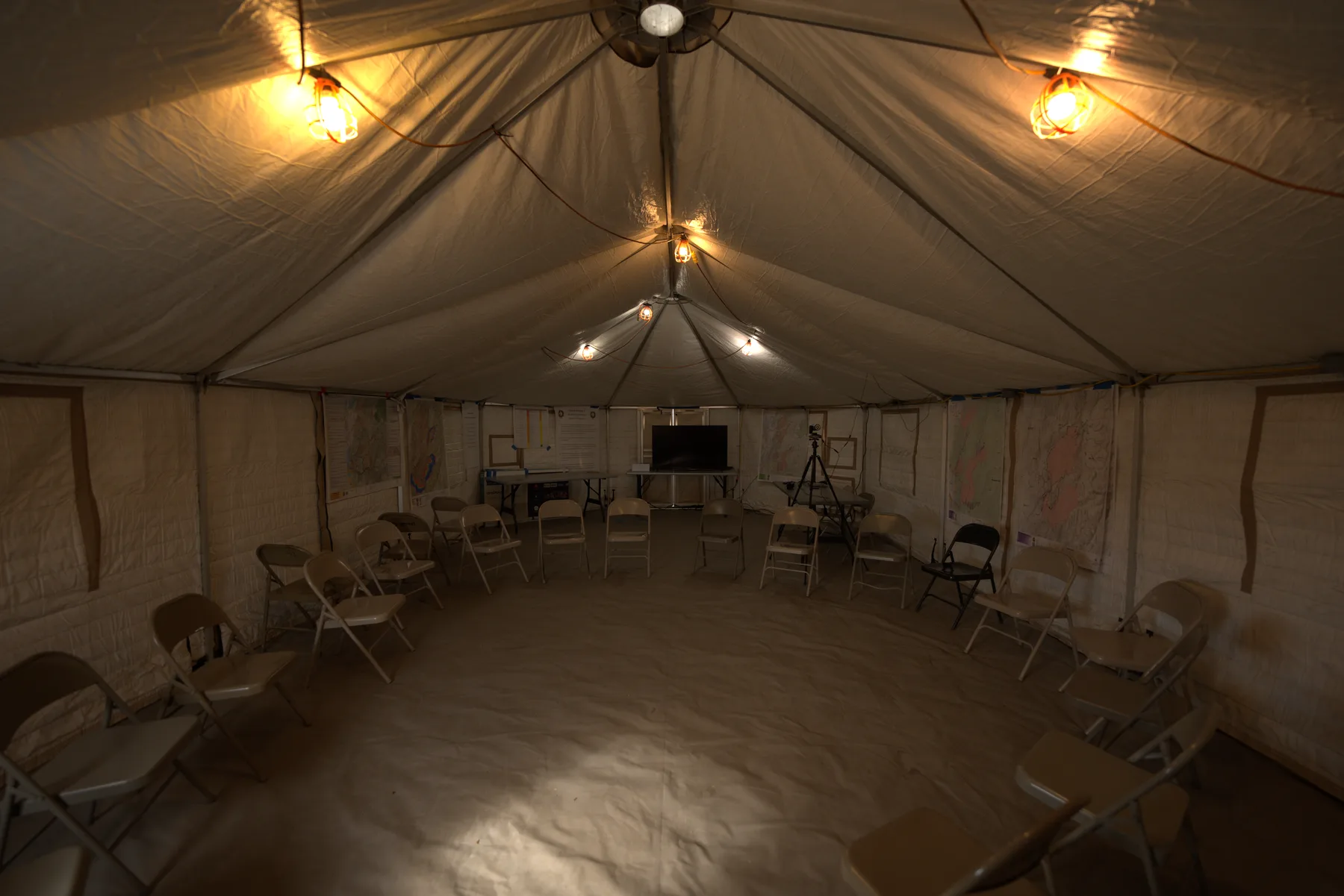 Another briefing setup inside an Evergreen yurt, chairs ringing the canvas wall