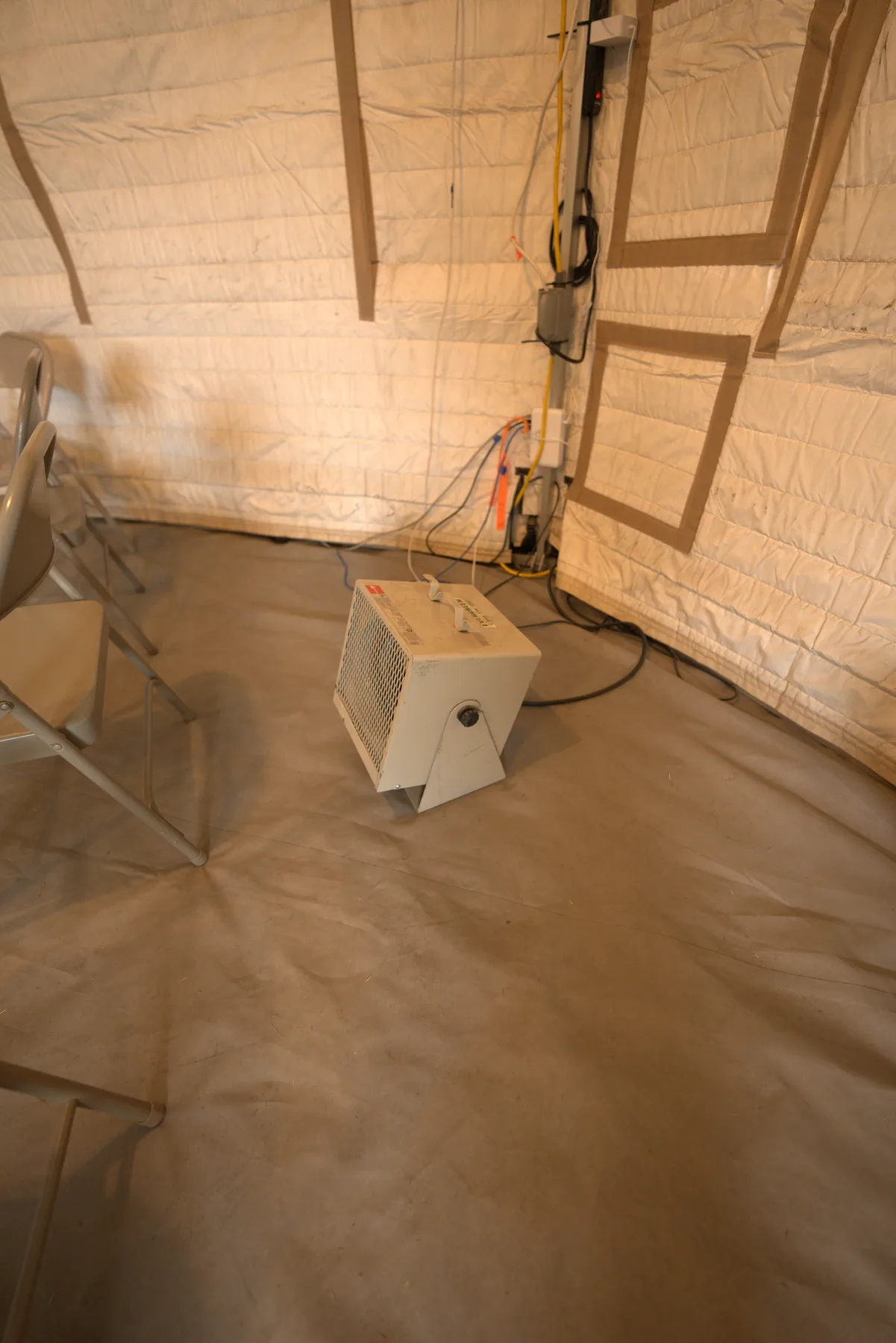 The inside of an Evergreen yurt with a heater set in the canvas