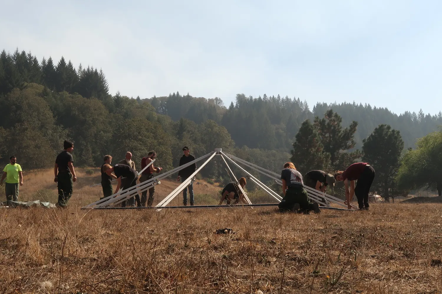 An Evergreen Resource crew raising tent frames in the field